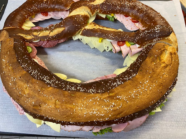 Große Brezel belegt mit Wurst und Käse